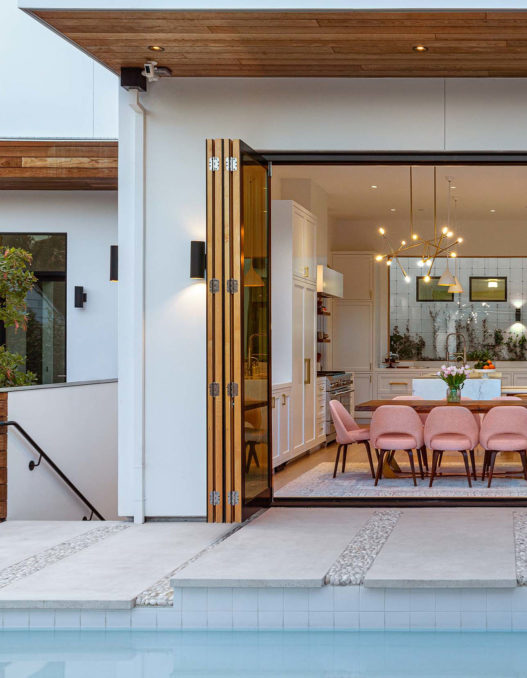 view from pool to dining area in warm modern home